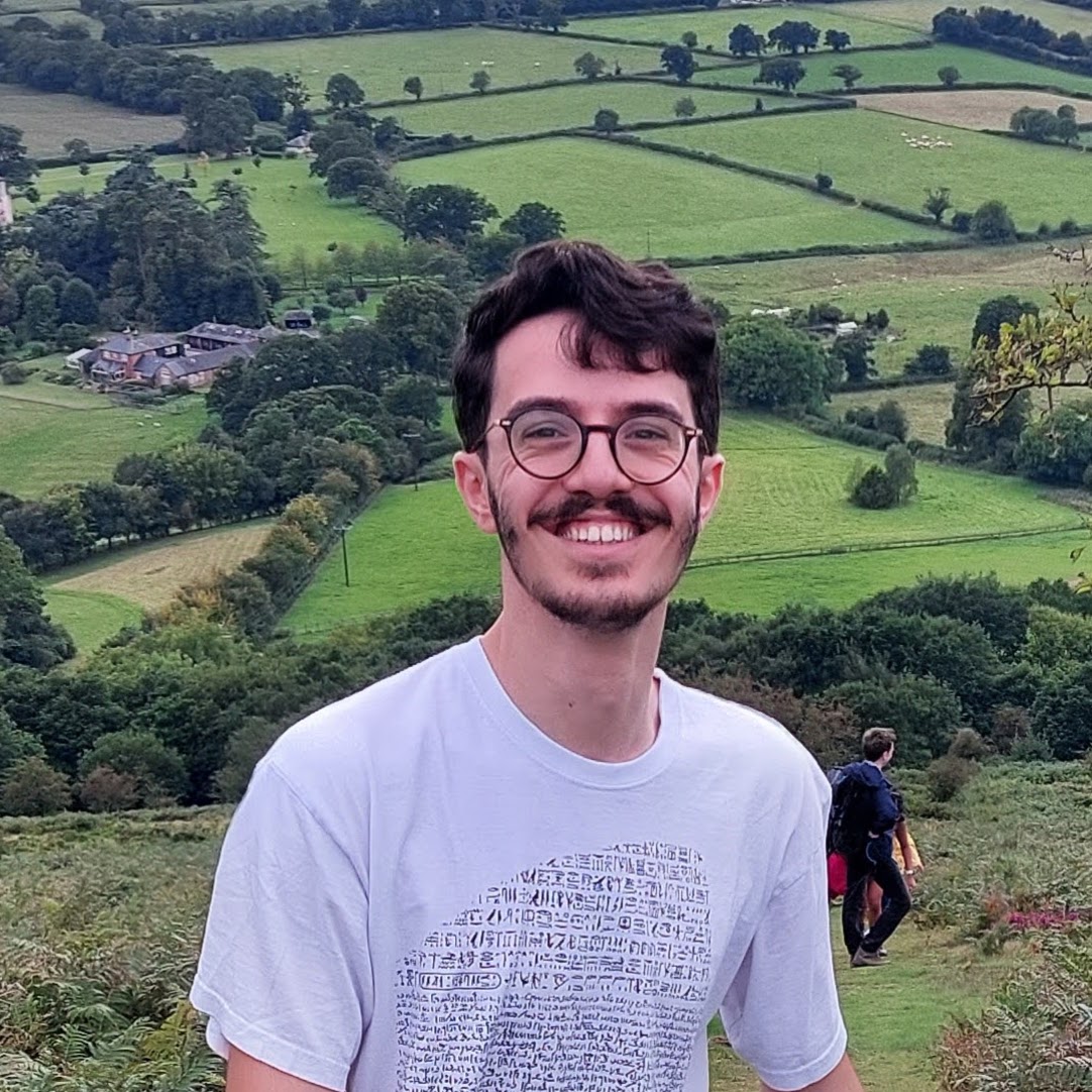 Sam standing on a hillside wearing a Rosetta Stone shirt